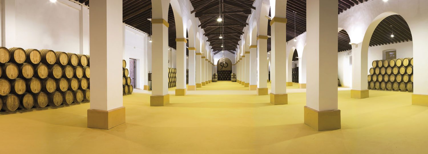 Nave de crianza con arcos encalados y botas de roble